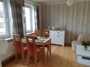 a living room with a table and chairs and a kitchen at Wiesenblick in Pellworm