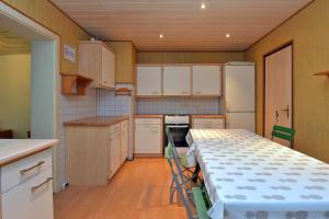 una cocina con armarios blancos y una mesa. en Monteurhaus-Arbeiterunterkunft Haus Markus Suhl, en Suhl