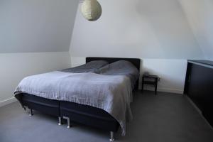 a bedroom with a bed and a night stand at Vissershuisje aan de waddenzee in Paesens