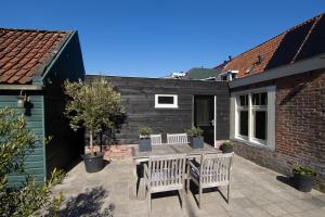 a patio with two chairs and a table at Vissershuisje aan de waddenzee in Paesens