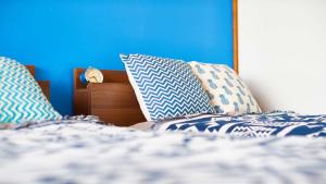 a bed with blue and white pillows on it at zaimokuza seasons in Kamakura