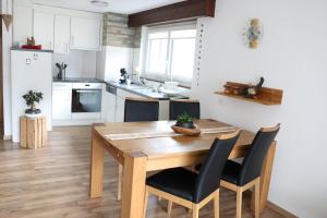 Il comprend une cuisine et une salle à manger avec une table et des chaises en bois. dans l'établissement Ferienhaus Alea, à Saas-Grund