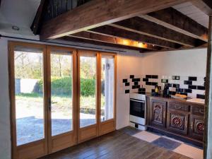 a kitchen with sliding glass doors and a stove at Ti Baou in Châteauneuf-du-Faou