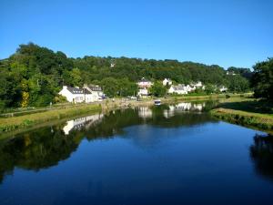 a view of a river with houses in the background at Ti Baou in Châteauneuf-du-Faou