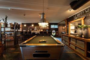 uma mesa de bilhar num quarto com um bar em Hotel Buxus em Gasselte