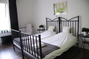 a bedroom with a black bed with white sheets and pillows at Hotel Buxus in Gasselte