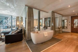 a large living room with a tub and a couch at Matterhorn FOCUS Design Hotel in Zermatt