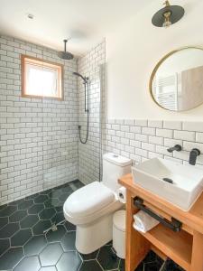 La salle de bains est pourvue de toilettes blanches et d'un lavabo. dans l'établissement AKA Patagonia, à Puerto Natales