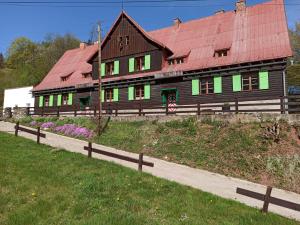 une grande maison en bois avec un toit rouge dans l'établissement Dom Pod Ptasznicą, à Kudowa-Zdrój