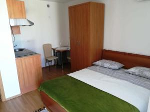 1 Schlafzimmer mit einem Bett, einer Küche und einem Tisch in der Unterkunft Prenočišča Iris in Sežana