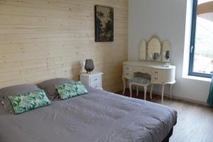 1 dormitorio con cama, tocador y espejo en chambres d’hôte le breuil, en Sarlat-la-Canéda