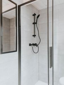 a shower with a glass door in a bathroom at Eko Domek w górach in Korbielów