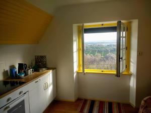 a kitchen with a window with a view of the countryside at Roz Melen in Châteauneuf-du-Faou