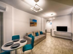 Una sala de estar con un sofá, una mesa y sillas. en Sunway - Pool & Spa Beach Resort, en Mamaia Nord – Năvodari