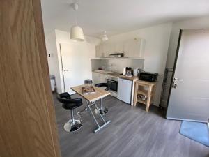 - une petite cuisine avec une table et des chaises dans la chambre dans l'établissement Charmant studio pour étudiant seul ou à 2, à Villeneuve-lès-Maguelone
