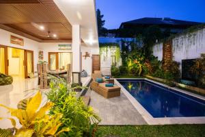 a house with a swimming pool in the yard at MasBro ART Villas in Seminyak