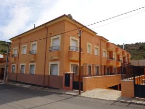 un edificio naranja al lado de una calle en Lagunas Ruidera 16 Agua y Placer, en Ruidera