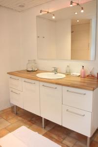 uma casa de banho com um lavatório branco e um espelho. em Tøndegården 3 rooms apartment em Odense