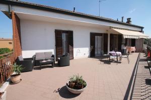 eine Terrasse mit Stühlen und Tischen auf einem Haus in der Unterkunft DA NONNA RITA in Vigevano