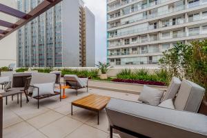 een dakterras met stoelen, tafels en gebouwen bij Audaar Jacques Pillon Residencial - Centro de São Paulo in Sao Paulo