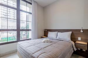 ein Schlafzimmer mit einem großen Bett und einem großen Fenster in der Unterkunft Audaar Jacques Pillon Residencial - Centro de São Paulo in São Paulo