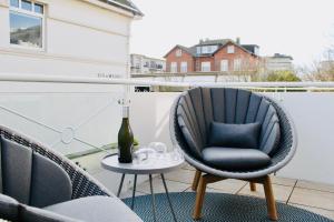 a bottle of wine sits on a table on a balcony at Sellminchen Sylt in Westerland (Sylt)