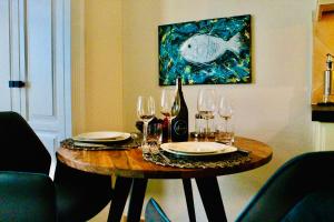 a dining room table with wine glasses and a painting at Sellminchen Sylt in Westerland (Sylt)