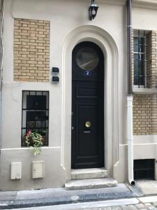 a black door on a white building with a window at Les Berceaux de la Cathedrale in Reims