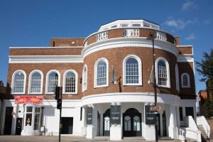 un gran edificio de ladrillo en una esquina de la calle en 13 The Grosvenor, luxury flat, central Newmarket, en Newmarket