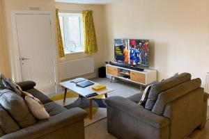 a living room with two couches and a flat screen tv at 13 The Grosvenor, luxury flat, central Newmarket, in Newmarket