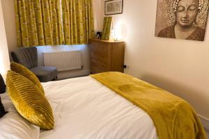 a bedroom with a bed with a yellow blanket on it at 13 The Grosvenor, luxury flat, central Newmarket, in Newmarket