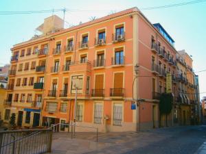 an orange building with balconies on a street at Hotel La Milagrosa in Alicante