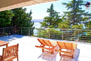 two chairs sitting on a deck with a view of the water at Apartmani Ribarica**** in Karlobag