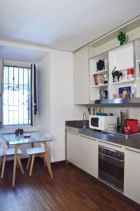 una pequeña cocina con mesa y microondas en Room Inn, en Milán