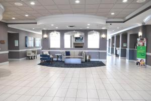 a lobby of a hospital with a couch and chairs at Holiday Inn Valdosta Conference Center, an IHG Hotel in Valdosta