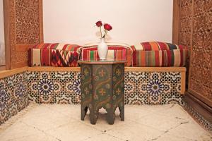 a vase with a flower on a table in a room at Riad Daria Suites & Spa in Marrakech