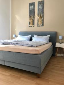 a bed in a bedroom with two pictures on the wall at Haus Meeresbrise Haus Karin in Norderney