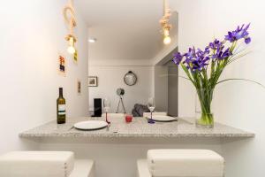stół z dwoma talerzami i wazon z fioletowych kwiatów w obiekcie Guest House 4U - Povoa seaside w mieście Póvoa de Varzim