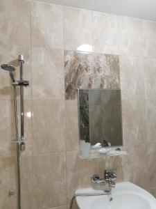 a bathroom with a shower and a sink and a mirror at Casa Del Mar in Primorsko +32 photos