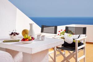 una mesa con un bol de fruta y una silla en Nakou Village, en Koutsounari