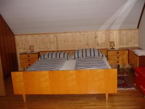 ein Schlafzimmer mit einem Holzbett mit zwei gestreiften Kissen in der Unterkunft Apartment Janschitz Gundersheim in Gundersheim