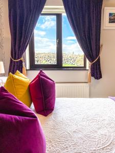 a bedroom with purple curtains and a bed with colorful pillows at Daly's House in Doolin