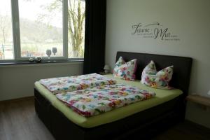 a bed in a bedroom with a bedspread and pillows at Suite Am Radweg in Pittenbach