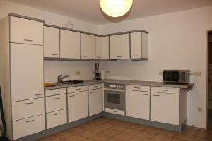 a kitchen with white cabinets and a microwave at Chrissi und Micha in Remscheid