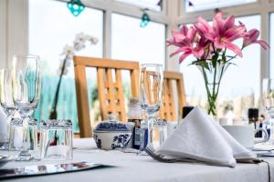 a table with glasses and a vase of flowers on it at Daly's House in Doolin