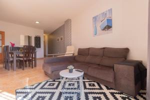 ein Wohnzimmer mit einem Sofa und einem Tisch in der Unterkunft THREE BEDROOM APARTAMENT NEAR SANTA CRUz 1A in Santa Cruz de Tenerife