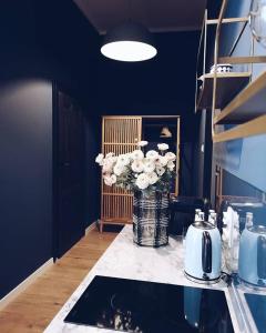 a vase of flowers on a counter in a kitchen at Rost Apartments in Bielsko-Biała +42 photos