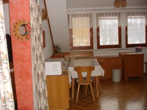 eine Küche mit einem Tisch, Stühlen und Fenstern in der Unterkunft Apartment Janschitz Gundersheim in Gundersheim