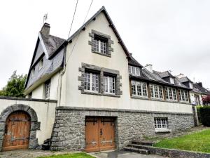 an old stone house with two doors and windows at Roz Melen in Châteauneuf-du-Faou