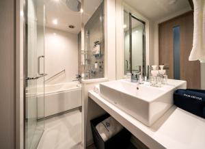 a white bathroom with a sink and a shower at Daiwa Roynet Hotel Sendai Ichibancho PREMIER in Sendai